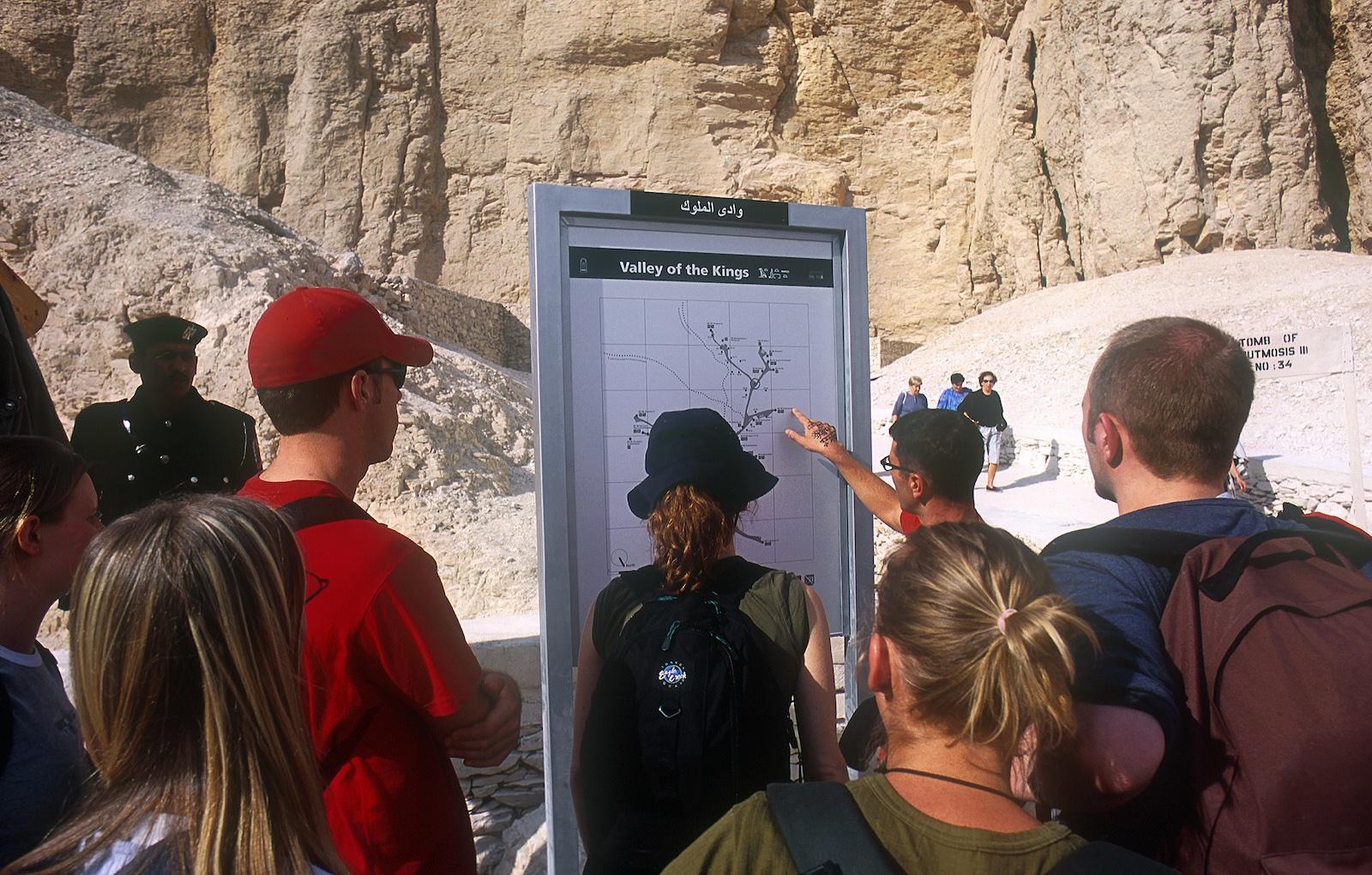 Tour guide lecturing in front of new information sign installed by the Theban Mapping Project.