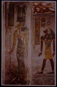 Hathor, "mistress of the west," in the tomb of Rameses III, in a relatively rare represenation with the head of a cow and two tall ostrich feathers, along with the cow horns and sun disk more usual to this goddess.  In the background is the monkey-headed