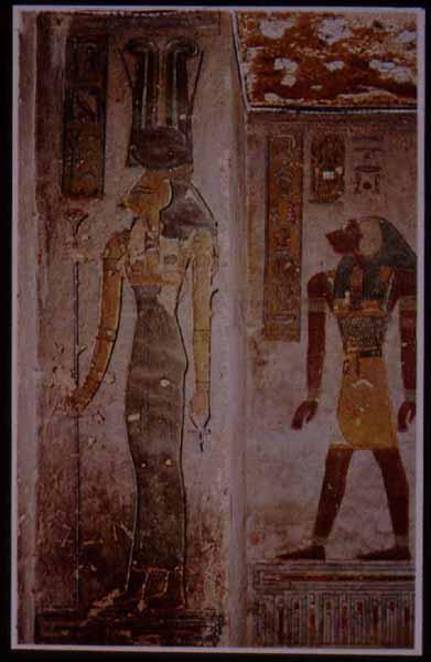 Hathor, "mistress of the west," in the tomb of Rameses III, in a relatively rare represenation with the head of a cow and two tall ostrich feathers, along with the cow horns and sun disk more usual to this goddess.  In the background is the monkey-headed